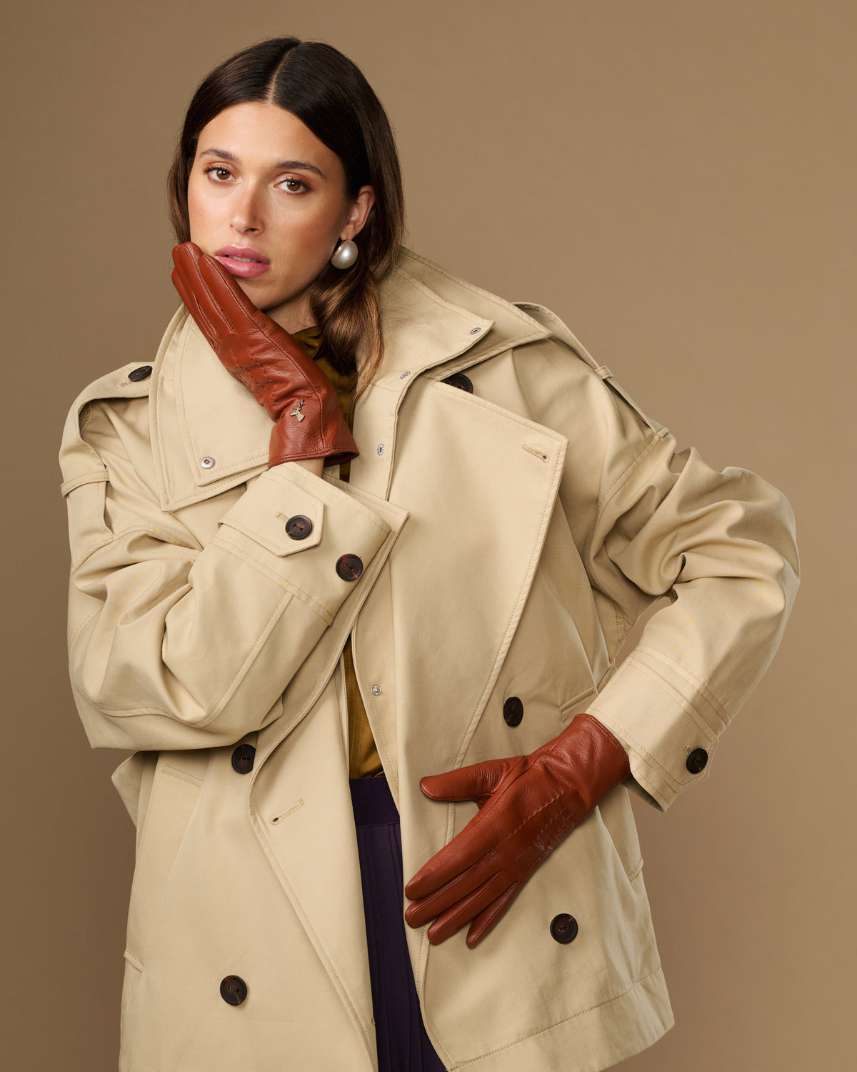 Cognac brown leather gloves with smooth surface and visible stitched paneling