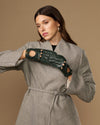 Dark green leather driving gloves with studded cutout design and round gold marks