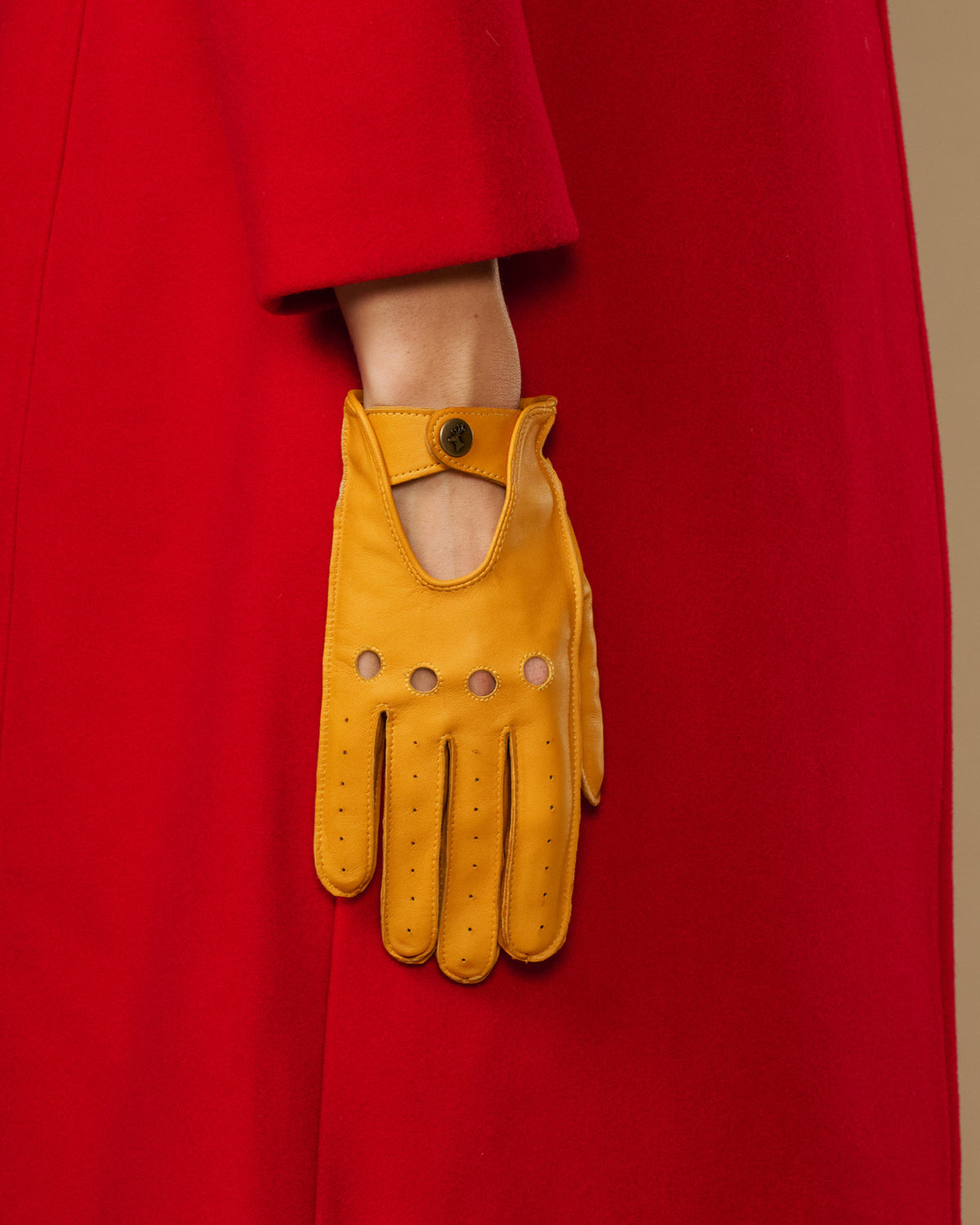 Yellow lambskin glove with oval cutout, button tab cuff and stitched fingers