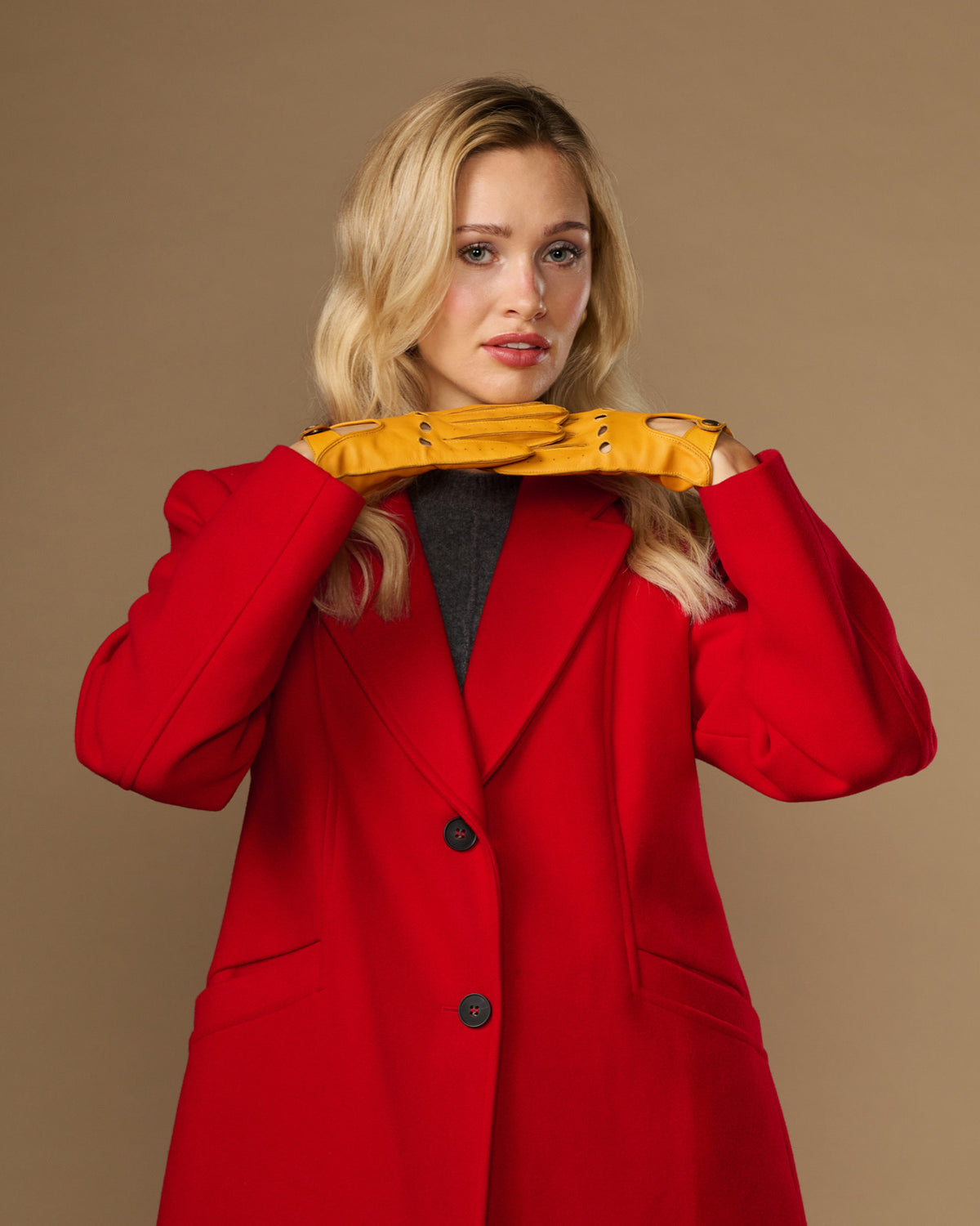 Yellow lambskin gloves worn together, touchscreen fingertips and cuff buttons