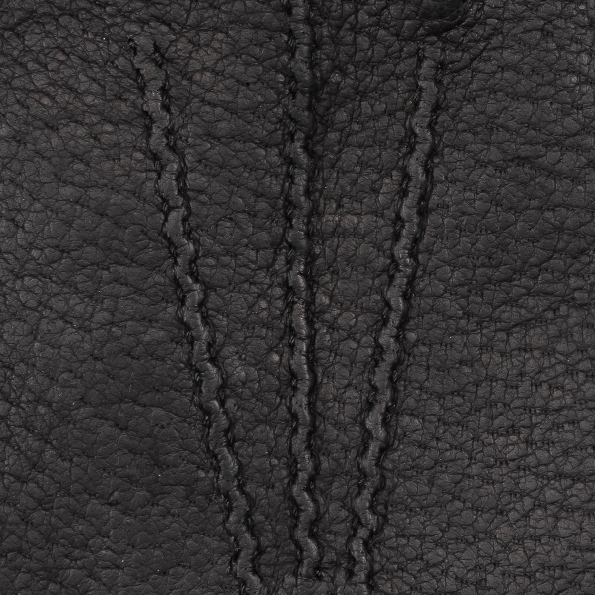 Close-up of textured dark leather glove surface with stitched panel detailing