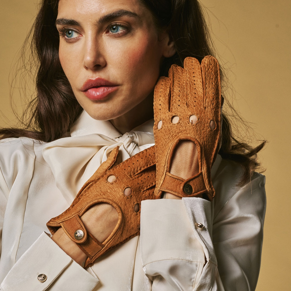 Women’s cognac driving gloves with button wrist tabs and perforated finger panels