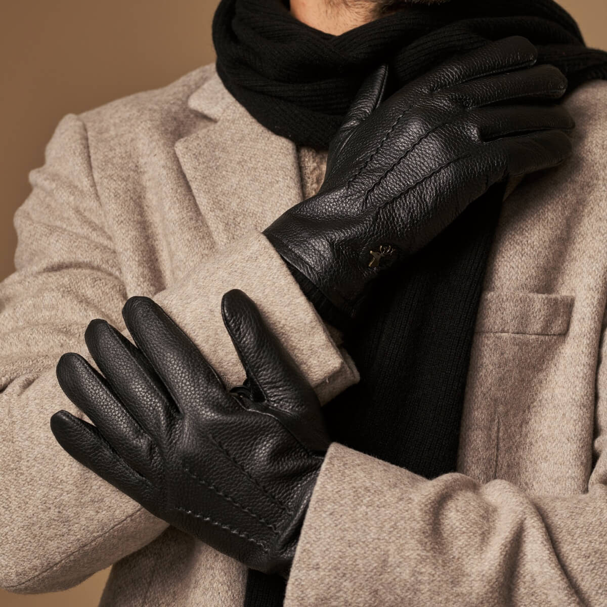 Close-up of black leather glove fingers and thumb seam with wool-lined cuff edge