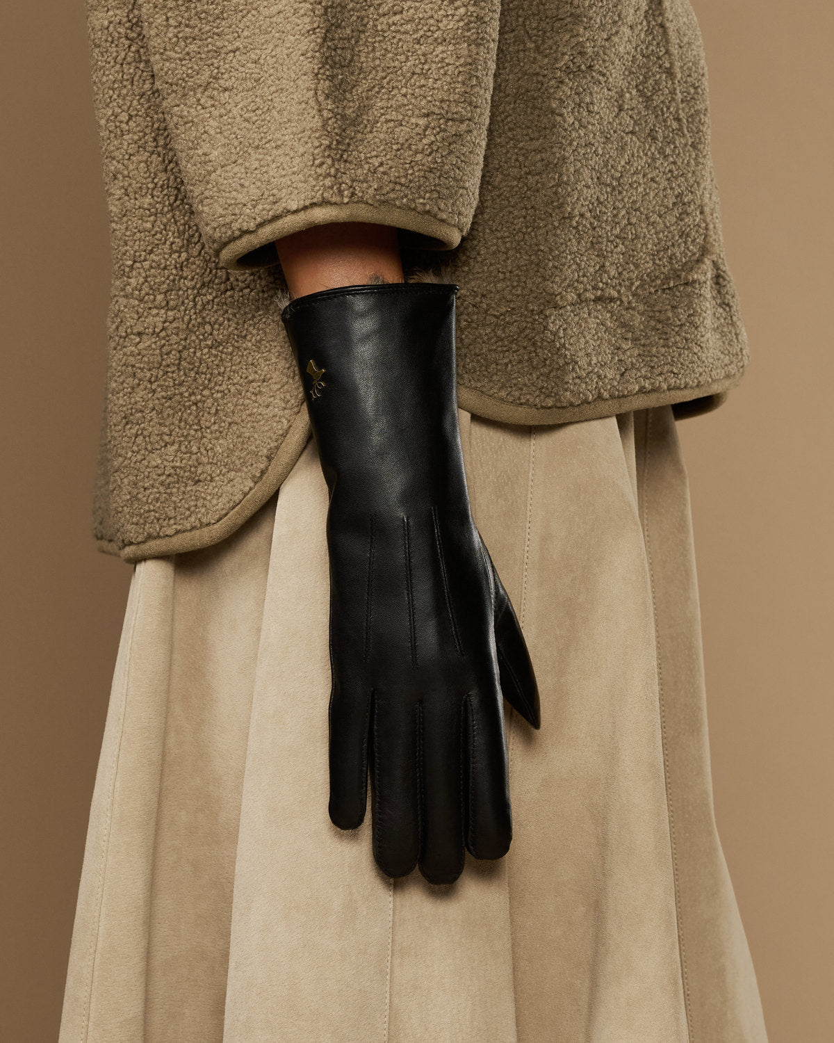 Black leather gloves with long silhouette and pointed fur-lined wrist
