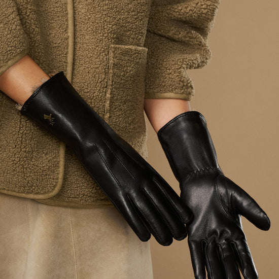 Pair of black leather gloves with plush fur-lined cuffs and touchscreen tips