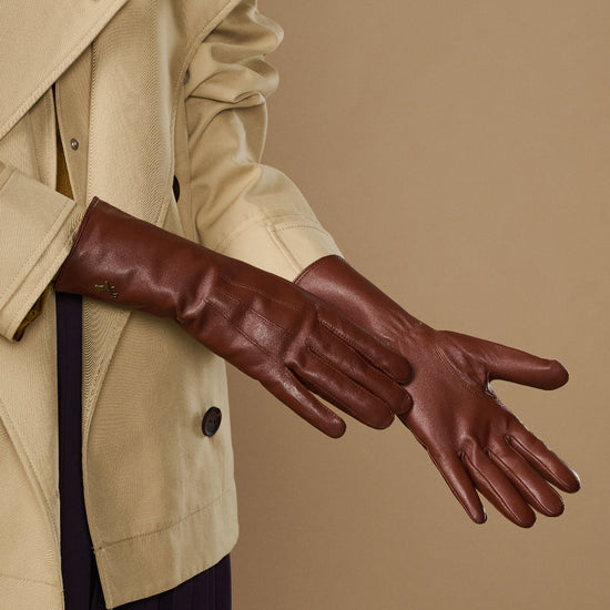 Side view of extra-long brown leather gloves with stitched knuckle seams
