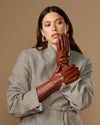 Pair of extra-long cognac leather gloves with rabbit-fur cuffs, worn close-up