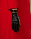 Black leather gloves with gold-tone buckle on wrist and fingerless design