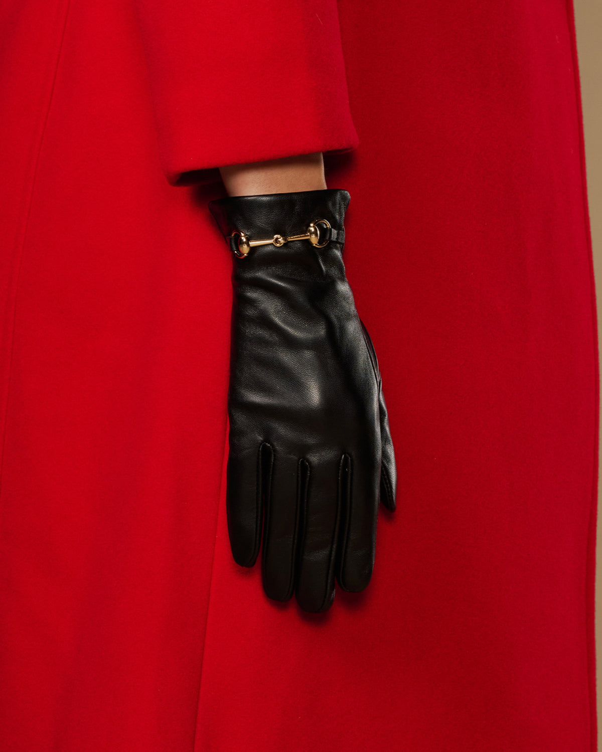 Black leather gloves with gold-tone buckle on wrist and fingerless design