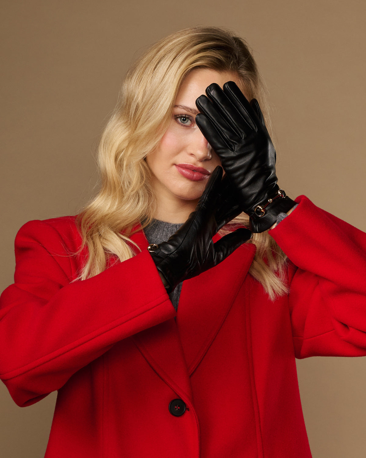 Black leather gloves worn with gold-tone buckle cuff