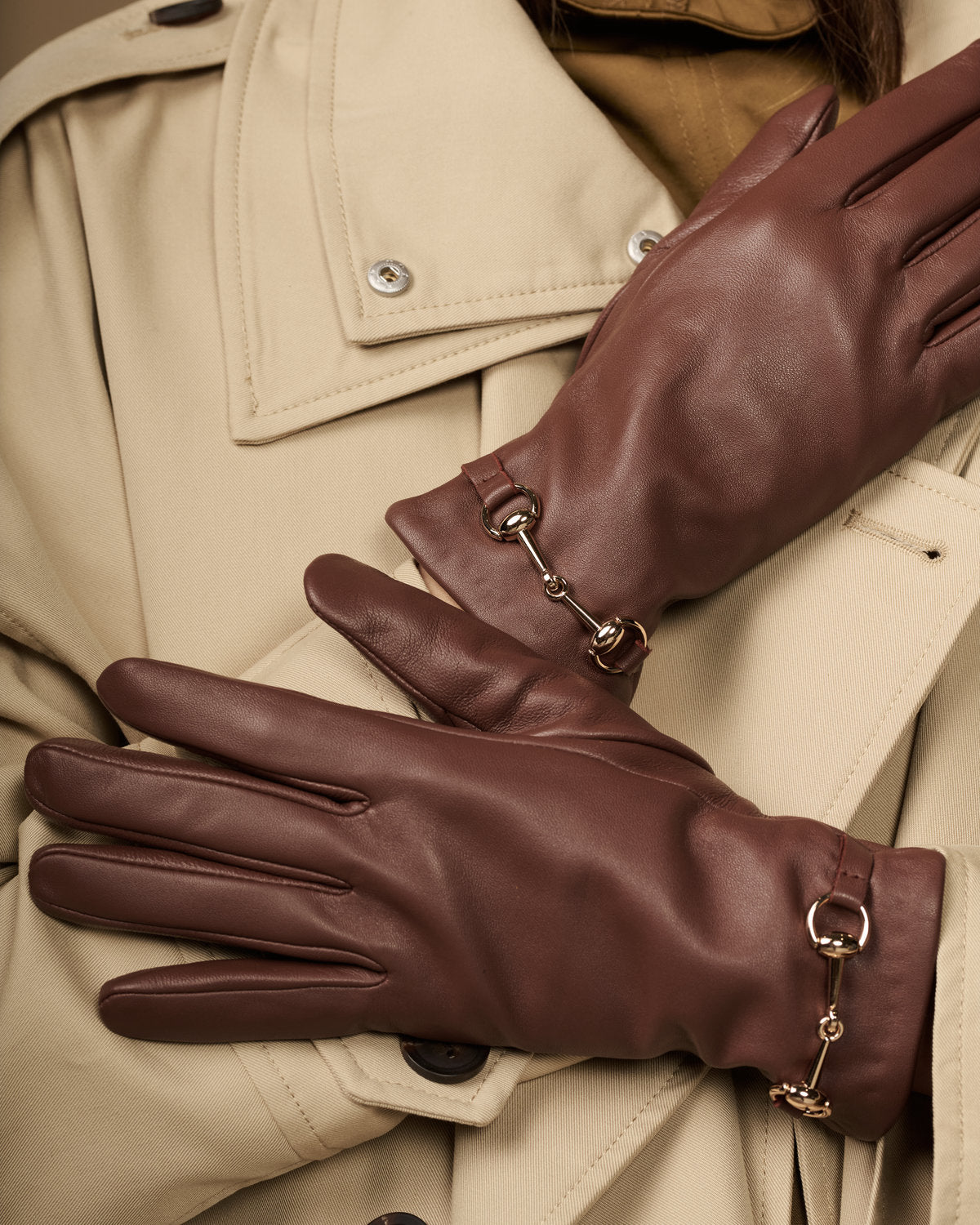 Dark brown lambskin gloves with gold-tone buckle hardware and shaped finger panels