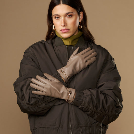 Taupe lambskin leather gloves with gold-tone buckle straps on the cuffs