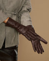 Long dark brown leather glove close-up with smooth surface