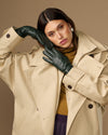 Dark green leather long gloves covering hands and wrists in a close-up