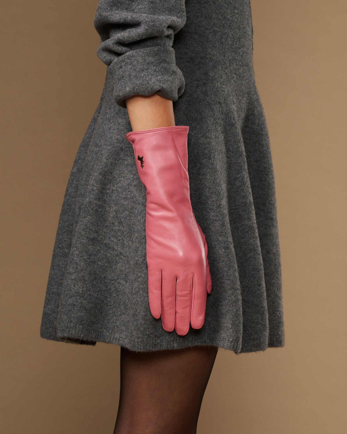 Pink leather glove with long cuff reaching past the wrist and finger seams