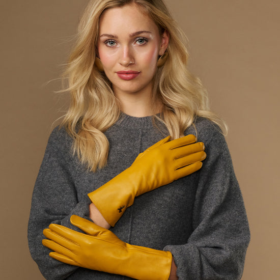 Yellow extra-long leather gloves with cashmere lining; cuff logo and touchscreen fingertips visible