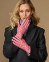 Women’s pink leather gloves held together, showing smooth back and stitched fingers