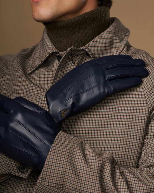 Navy leather glove close-up with stitched seams and small logo on the back