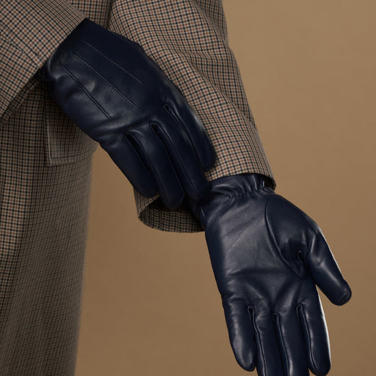 Single navy leather glove on extended hand, showing palm and finger seams