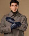 Navy leather gloves on a man’s hands, one glove held up across the other