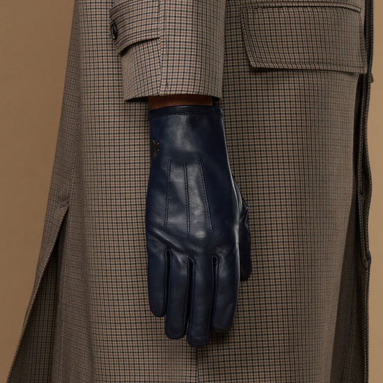 Navy leather glove with cuff detail, worn under a plaid coat sleeve