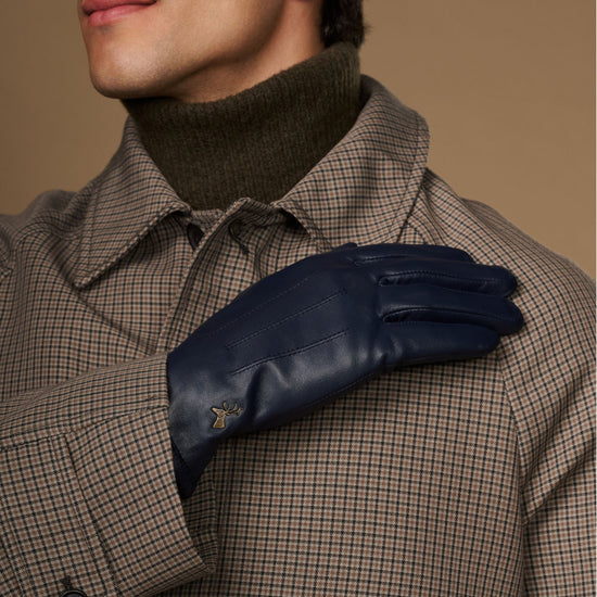 Navy leather glove close-up near the collar, showing stitched knuckles and logo