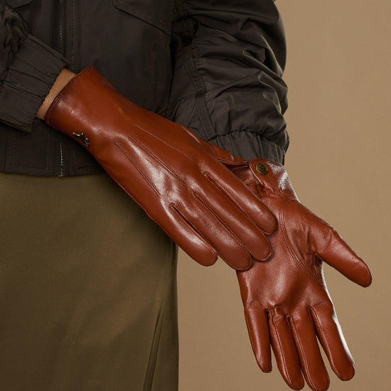 Women’s cognac leather gloves with curved seams and snug wrist band detail