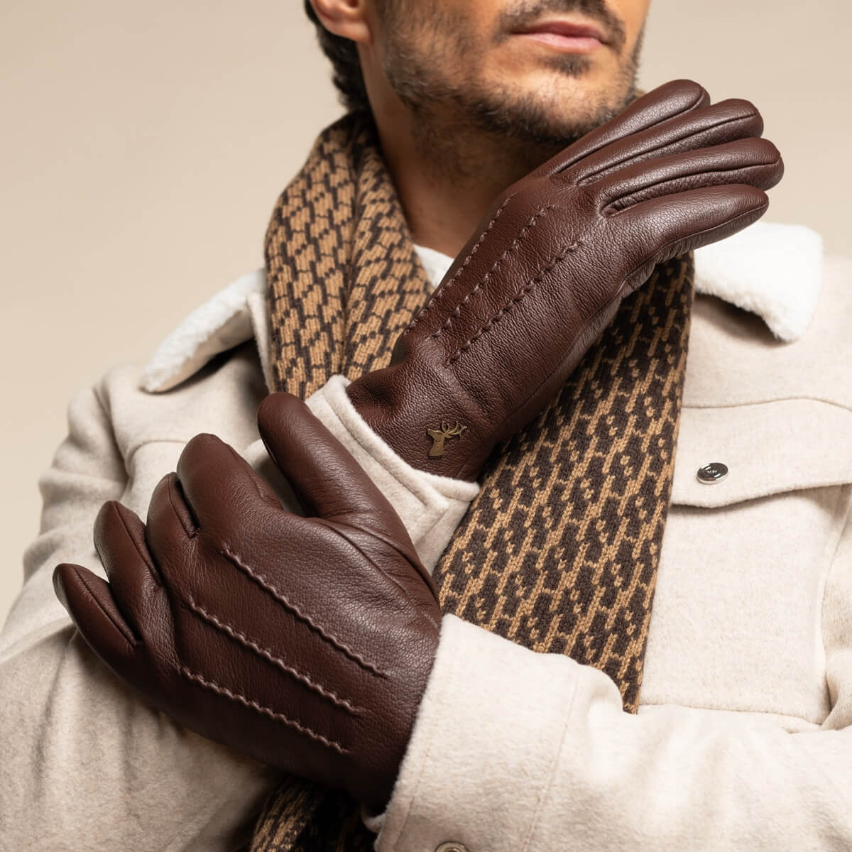 Brown leather gloves with faux fur lining at the wrist and decorative seam stitching