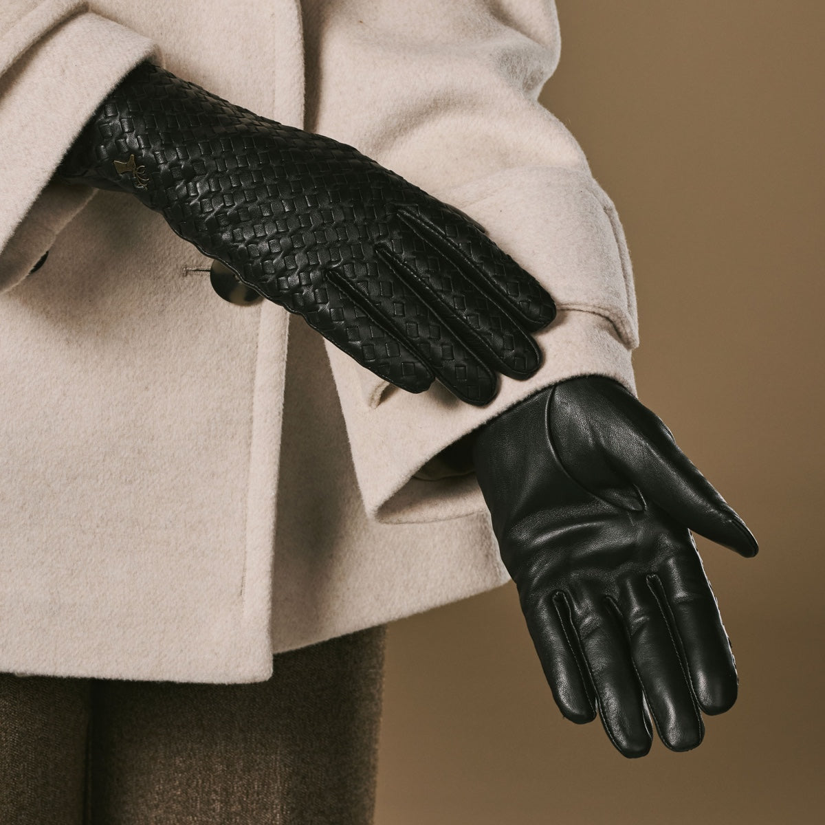 Close-up of black basketweave gloves with textured palm and wool-lined cuff