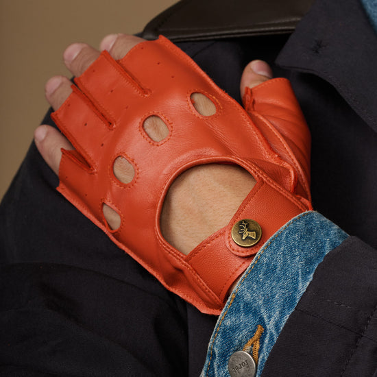 Men's orange fingerless lambskin driving gloves with perforated finger details and badge snap