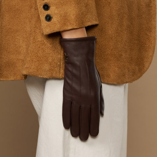 Brown leather gloves with fleece lining, one glove hanging in front view