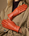 Orange leather gloves with warm fleece lining, close-up view of palm and seams