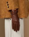 Close-up of brown leather glove side zip and fingertips, cashmere-lined cuff