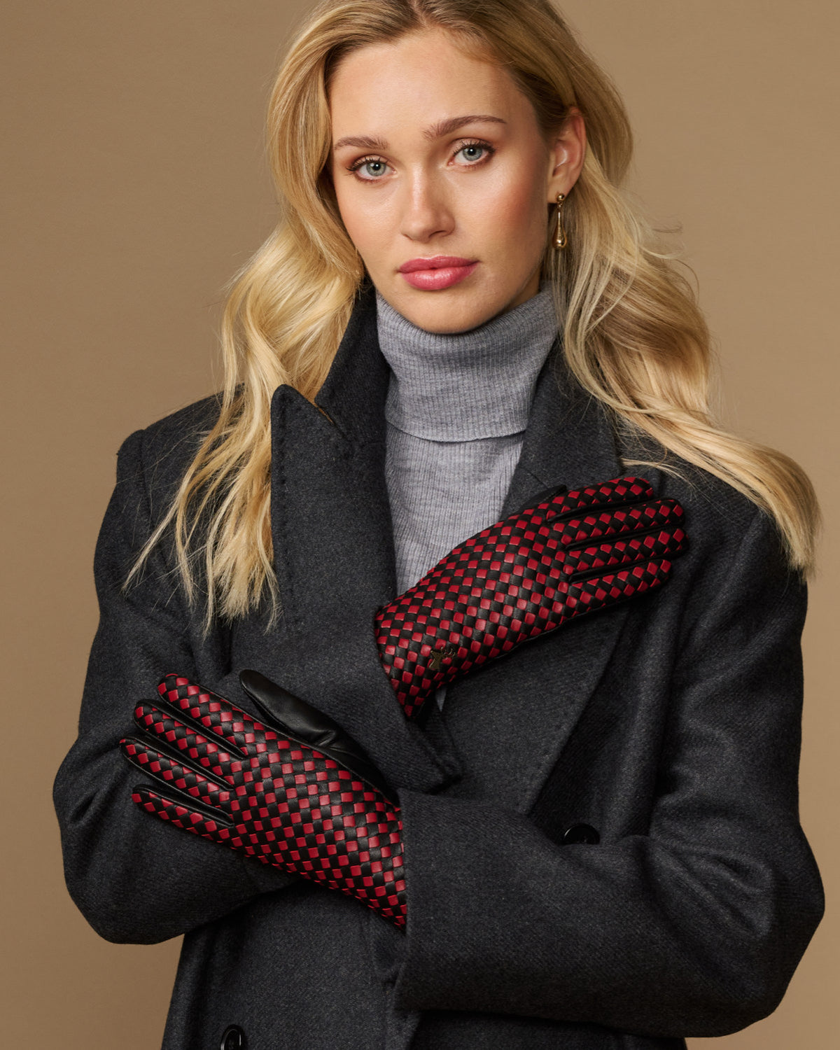 Women's black leather gloves with red and black checkered lining, worn with cuffs
