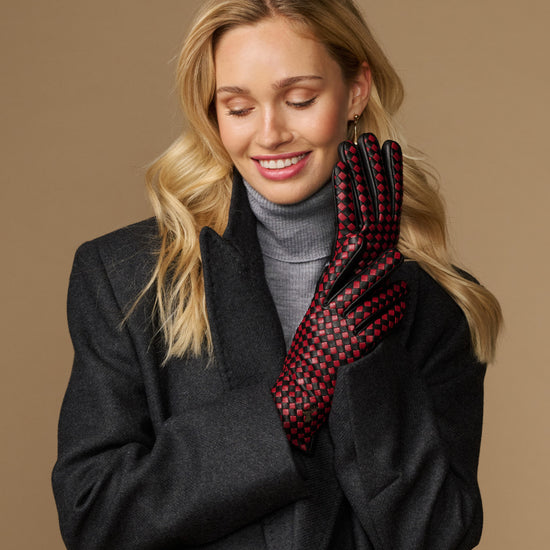 Women's black leather glove with red-and-black checkered interior, partial view