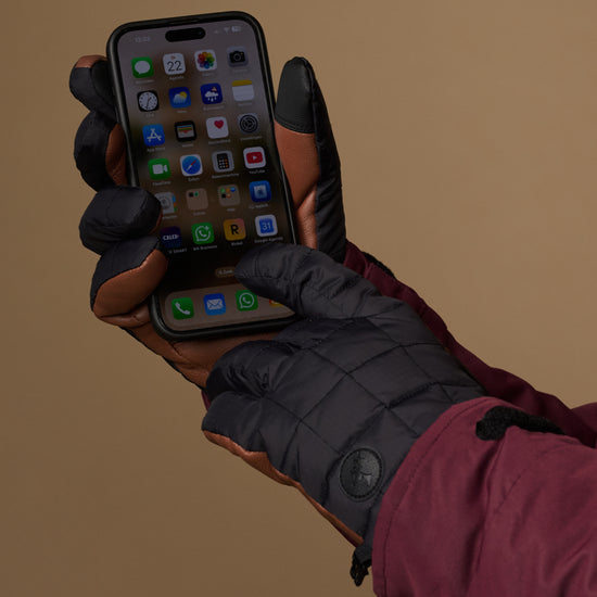 Men's touchscreen gloves holding a smartphone, padded dark gray fabric