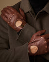 Brown leather driving gloves close-up with elastic wrist and touchscreen patch