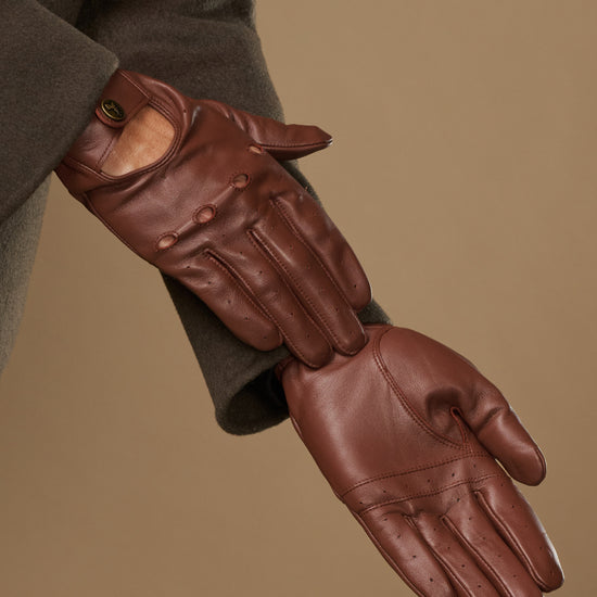 Brown leather driving gloves with stitched seams and fitted knuckle panels