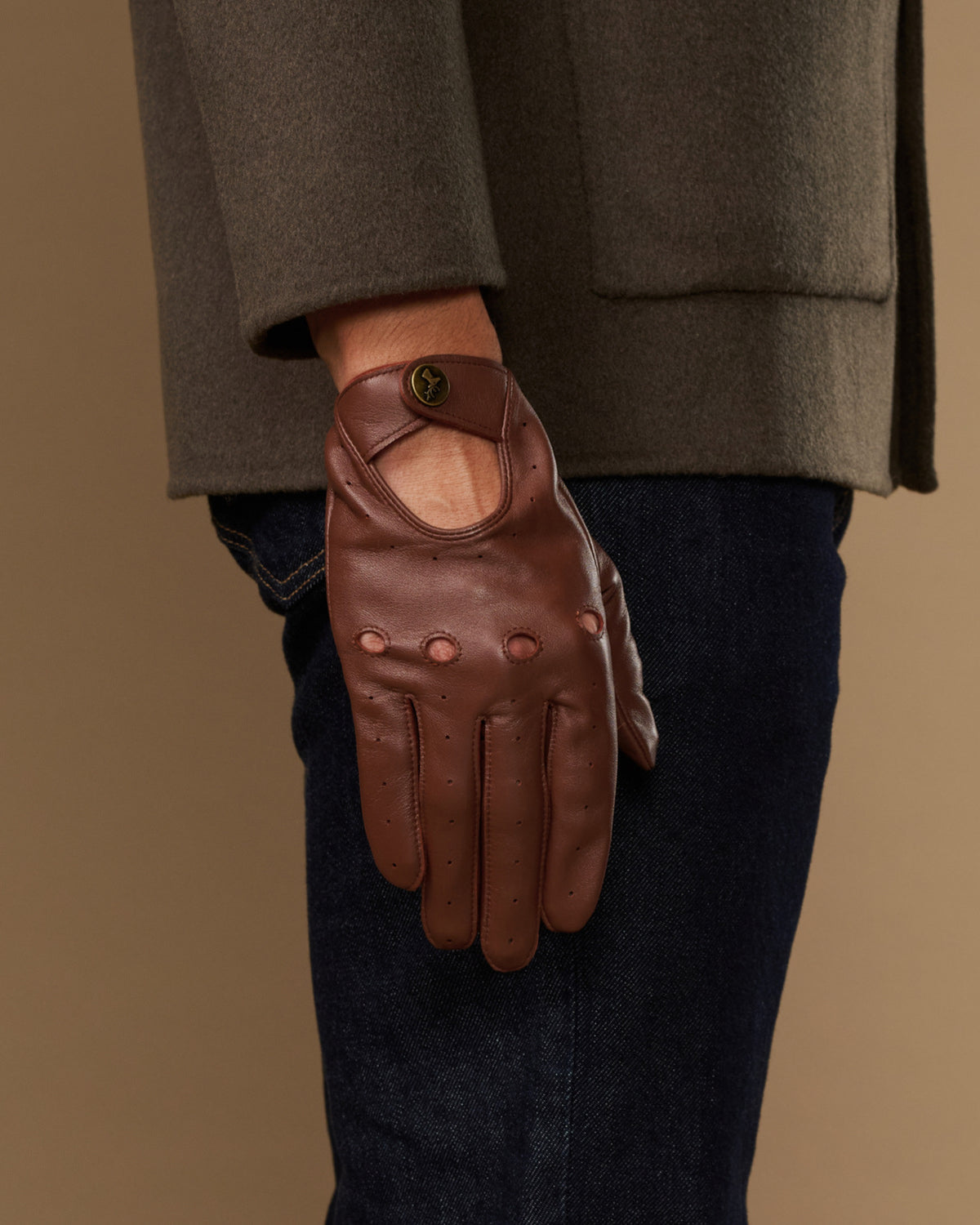 Brown leather driving gloves with elastic wrist and reinforced palm stitching