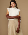 Chestnut brown leather opera gloves with long fit, one glove holding the other cuff