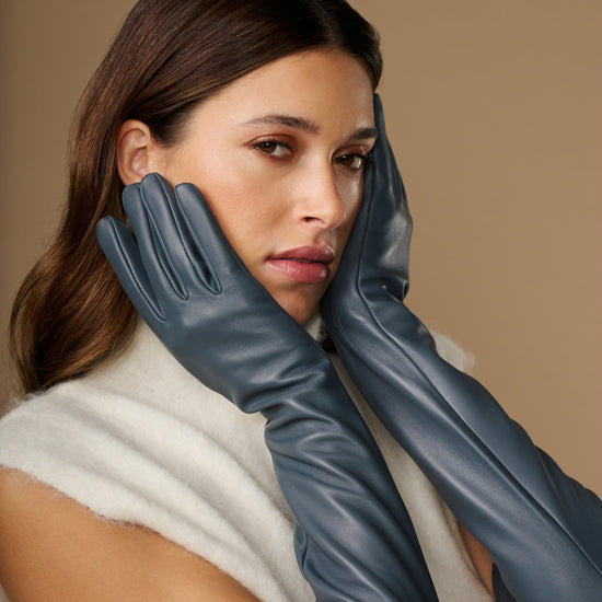 Women's grey leather gloves with silk lining and touchscreen fingertips, close-up view