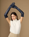 Navy leather opera gloves with long cuffs and silk lining, hands raised overhead