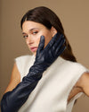 Navy leather opera gloves with long cuffs and silk lining, close side profile with gloves