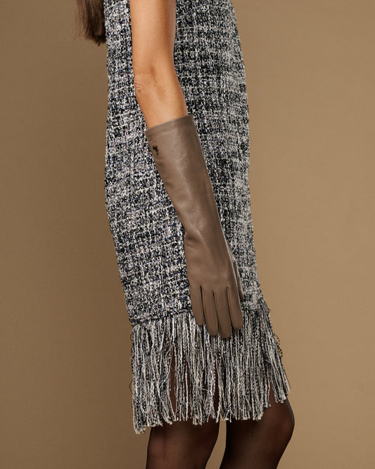 Taupe below-elbow leather glove on arm, long slim cuff with finger seams visible.