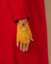 Yellow fingerless lambskin glove with thumb opening, snap cuff, and perforation panels