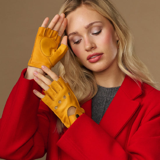 Yellow fingerless driving gloves with thumb opening and studded knuckle panels