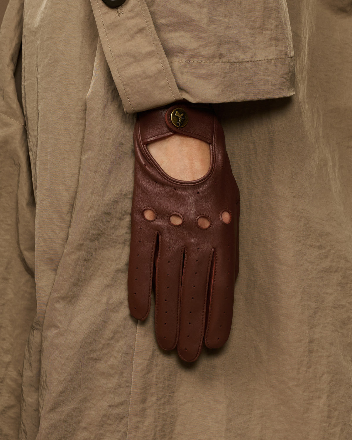 Brown leather gloves featuring an open palm panel and perforated finger rows