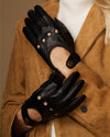 Pair of black leather driving gloves with studded accents and touchscreen fingertips.