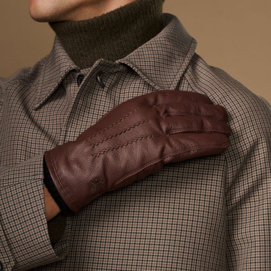 Brown leather glove worn on arm with fleece-lined cuff